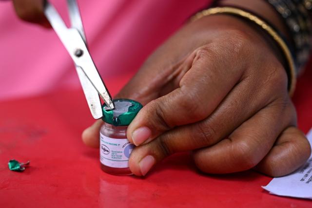 A health worker opens an oral polio vaccine vial during the nationwide Pulse Polio Immunisation Program at a school in Bengaluru on June 28, 2026. (Photo by Idrees MOHAMMED / AFP)