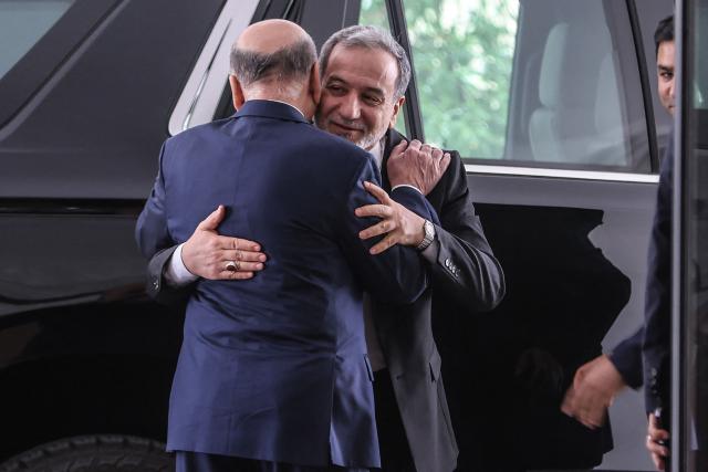 Iraqi Foreign Minister Fuad Hussein (Back) greets his Iranian counterpart, Foreign Minister Abbas Araqchi  upon his arrival for a meeting in Baghdad on July 28, 2026. Iran said on June 28, it was determined to defend its sovereignty after the latest US strikes on the country, as a fragile truce in the Middle East war hung in the balance. (Photo by AHMAD AL-RUBAYE / AFP)
