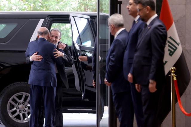 Iraqi Foreign Minister Fuad Hussein (Back) greets his Iranian counterpart, Foreign Minister Abbas Araqchi  upon his arrival for a meeting in Baghdad on July 28, 2026. Iran said on June 28, it was determined to defend its sovereignty after the latest US strikes on the country, as a fragile truce in the Middle East war hung in the balance. (Photo by AHMAD AL-RUBAYE / AFP)