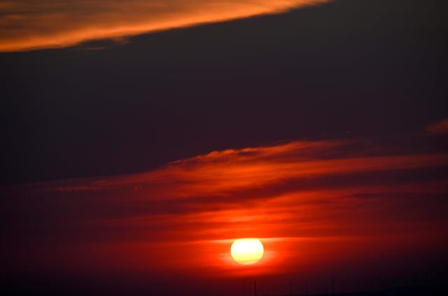 The sun goes up on early June 28, 2026, over the Drachenberg mountain in Berlin, as the German capital is expected to reach teperatures around 40 degrees Celsius during a heatwave in Europe. Tens of millions are braving a weekend of extreme temperatures in Europe as a deadly heatwave moves eastwards, with some countries announcing rising death tolls and health services warning of saturation. While some mild relief is expected Sunday in western Europe, German forecasters are warning that more temperature records could still be broken over the weekend as eastern countries issue a slew of red alerts for the coming days. (Photo by RALF HIRSCHBERGER / AFP)