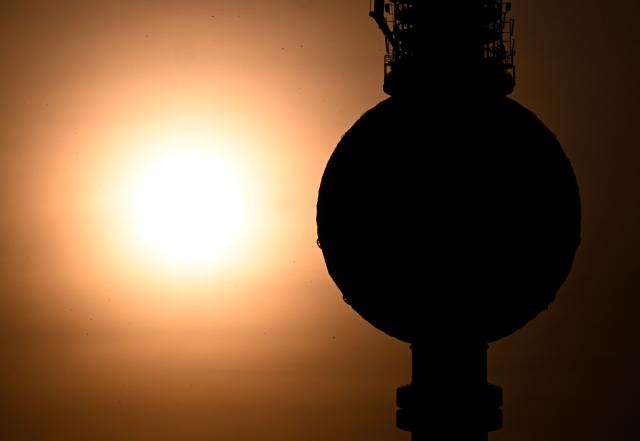 Berlin's landmark TV tower is silhouetted next to the rising sun on early June 28, 2026, in Berlin, as the German capital is expected to reach teperatures around 40 degrees Celsius during a heatwave in Europe. Tens of millions are braving a weekend of extreme temperatures in Europe as a deadly heatwave moves eastwards, with some countries announcing rising death tolls and health services warning of saturation. While some mild relief is expected Sunday in western Europe, German forecasters are warning that more temperature records could still be broken over the weekend as eastern countries issue a slew of red alerts for the coming days. (Photo by RALF HIRSCHBERGER / AFP)