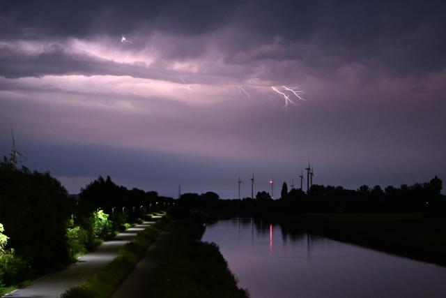 A lightning strikes during a storm over a canal in Sint-Pieters-Leeuw, near Brussels, on June 28, 2026. (Photo by Nicolas TUCAT / AFP)