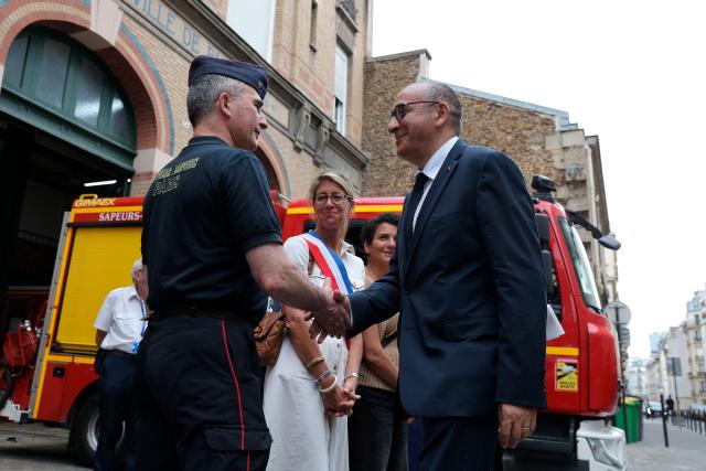 France's Interior Minister Laurent Nunez (R) shakes hands with General Arnaud de Cacqueray, head of the Paris Fire Department (BSPP), during his visit to a fire station to review the crisis management response to the heat wave in Paris on June 28, 2026. (Photo by Kenzo TRIBOUILLARD / AFP)