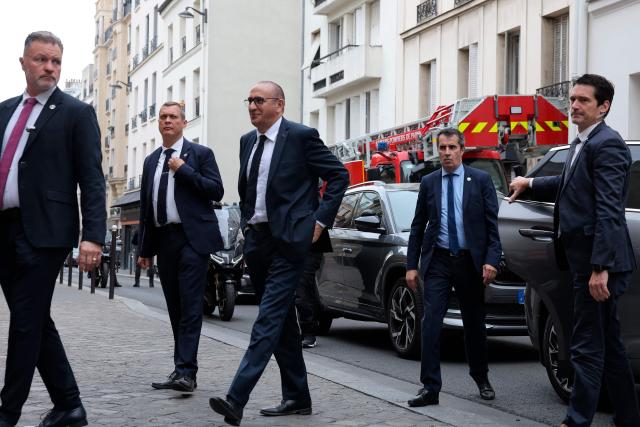 France's Interior Minister Laurent Nunez (C) arrives at a fire station to review the crisis management response to the heat wave in Paris on June 28, 2026. (Photo by Kenzo TRIBOUILLARD / AFP)