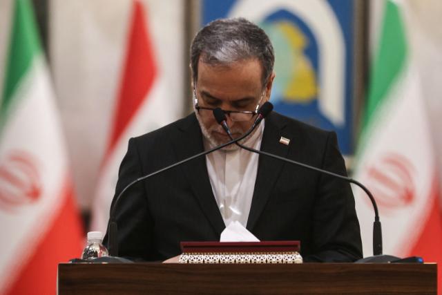 Iranian Foreign Minister Abbas Araqchi looks down at notes during a joint press conference with his Iraqi counterpart during their joint press conference following a meeting in Baghdad on July 28, 2026. Iran's foreign minister warned on June 28, that any challenge to the country's control of the strategic Strait of Hormuz would increase tensions despite ongoing peace negotiations to end the Middle East war. (Photo by AHMAD AL-RUBAYE / AFP)