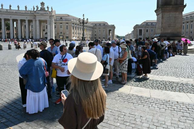 People queue in the shade as they wait for the Sunday Angelus prayer led by Pope Leo XIV in St. Peter's square at the Vatican on June 28, 2026. (Photo by Alberto PIZZOLI / AFP)