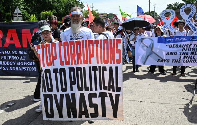 Protesters hold banners as they march during an anti-corruption rally in Manila on June 28, 2026. Hundreds of protesters including members of religious groups marched to the people power monument demanding accountability over a multi-billion-dollar infrastructure scandal that has seen scores of officials, lawmakers and construction firm owners accused of corruption. (Photo by Ted ALJIBE / AFP)