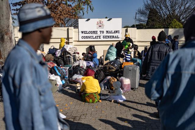 Malawian nationals queue in front of the Malawi Consulate General as others gather in Johannesburg on June 28, 2026. South Africans President Cyril Ramaphosa vowed on Thursday to crush any attempts to destabilise the nation during planned anti-immigrant marches next week, amid a wave of xenophobia. Citizen-led groups have set Tuesday 30 as a deadline for undocumented foreigners to leave and called for nationwide marches against illegal immigration, marking a crescendo in months of protests that have at times turned violent. (Photo by EMMANUEL CROSET / AFP)