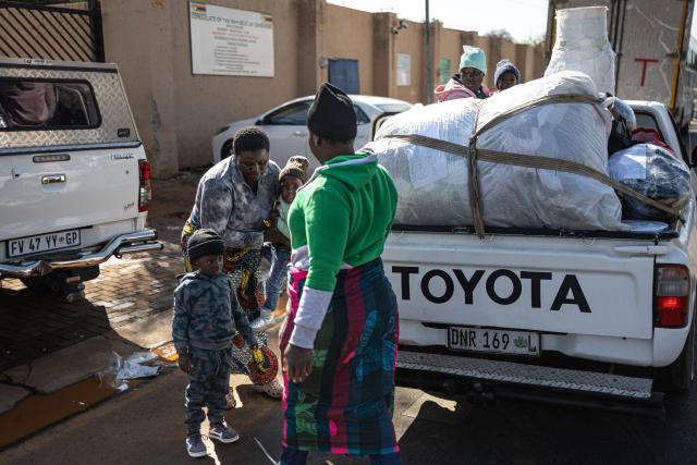 A pickup truck arrives outside the Zimbabwean Consulate General in Johannesburg on June 28, 2026, carrying a family with their belongings seeking assistance for return to Zimbabwe. South Africans President Cyril Ramaphosa vowed on Thursday to crush any attempts to destabilise the nation during planned anti-immigrant marches next week, amid a wave of xenophobia. Citizen-led groups have set Tuesday 30 as a deadline for undocumented foreigners to leave and called for nationwide marches against illegal immigration, marking a crescendo in months of protests that have at times turned violent. (Photo by EMMANUEL CROSET / AFP)