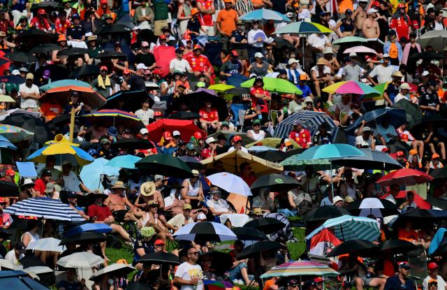 Spectators follow the Formula One Austrian Grand Prix under umbrellas to protect against against the sun at the Red Bull Ring race track in Spielberg, Austria on June 28, 2026. (Photo by Andrej ISAKOVIC / AFP)