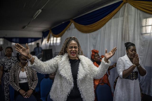 Worshippers join a crowd of both South African and foreign congregants as they gather to pray at the Supernatural Platform Global Ministries church of pastors Professor Vivian Besem Ojong and John Arinze, both of Nigerian origin, in Durban, on June 28, 2026. South Africans President Cyril Ramaphosa vowed on Thursday to crush any attempts to destabilise the nation during planned anti-immigrant marches next week, amid a wave of xenophobia. Citizen-led groups have set Tuesday 30 as a deadline for undocumented foreigners to leave and called for nationwide marches against illegal immigration, marking a crescendo in months of protests that have at times turned violent. (Photo by MARCO LONGARI / AFP)