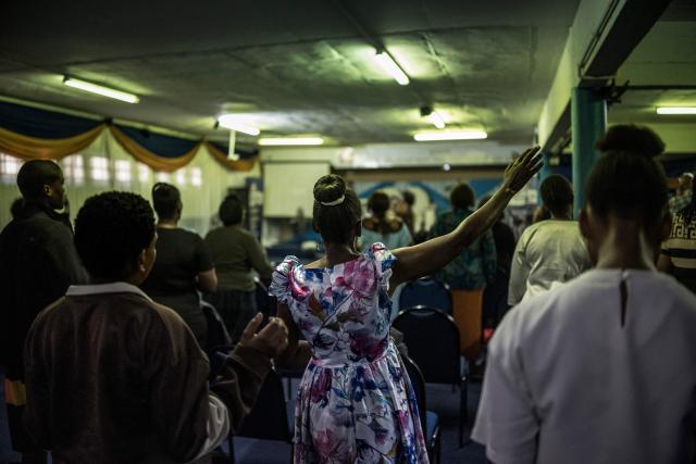 Worshippers join a crowd of both South African and foreign congregants as they gather to pray at the Supernatural Platform Global Ministries church of pastors Professor Vivian Besem Ojong and John Arinze, both of Nigerian origin, in Durban, on June 28, 2026. South Africans President Cyril Ramaphosa vowed on Thursday to crush any attempts to destabilise the nation during planned anti-immigrant marches next week, amid a wave of xenophobia. Citizen-led groups have set Tuesday 30 as a deadline for undocumented foreigners to leave and called for nationwide marches against illegal immigration, marking a crescendo in months of protests that have at times turned violent. (Photo by MARCO LONGARI / AFP)