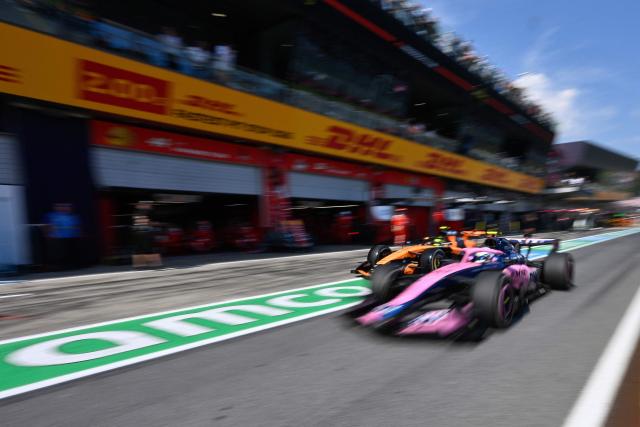 McLaren's British driver Lando Norris (L) comes in to the pit lane as Alpine's Argentine driver Franco Colapinto drives past during the Formula One Austrian Grand Prix at the Red Bull Ring race track in Spielberg, Austria on June 28, 2026. (Photo by Darko BANDIC / POOL / AFP)