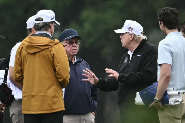 US President Donald Trump speaks with golf course architect Tom Fazio (center L) and Interior Secretary Doug Burgum (L, in white hat) and others at East Potomac Golf Links in Washington, DC, on June 28, 2026. (Photo by Kent NISHIMURA / AFP)
