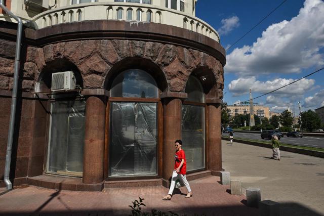 A woman walks past the empty display windows of a closed shop in Moscow on June 28, 2026. (Photo by Igor IVANKO / AFP)