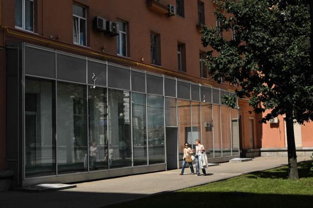 People walk past the empty display windows of a closed shop in Moscow on June 28, 2026. (Photo by Igor IVANKO / AFP)