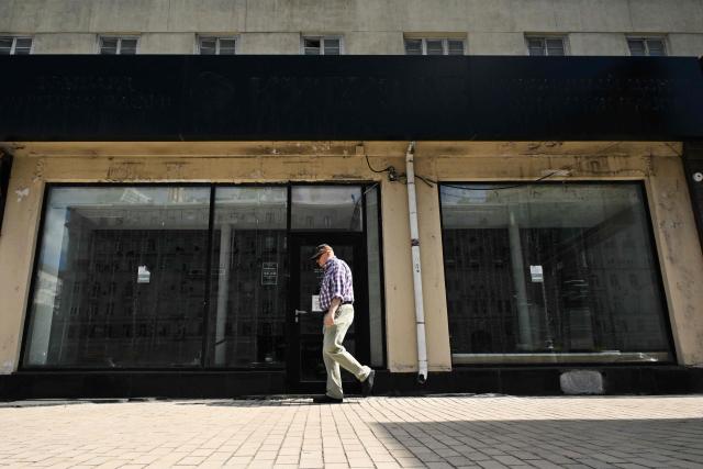 A man walks past the empty display windows of a closed shop in Moscow on June 28, 2026. (Photo by Igor IVANKO / AFP)