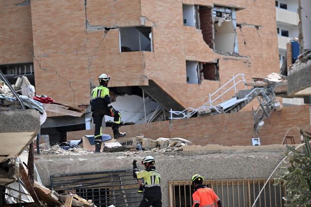 Spanish rescuers walk on the rubble of a collapsed building in Catia La Mar, La Guaira state, Venezuela, on June 28, 2026, following earthquakes. Thousands of rescuers, relatives and volunteers dig day and night through mounds of concrete to find survivors of the earthquakes that struck Venezuela more than three days ago, leaving nearly 1,500 dead and tens of thousands missing. (Photo by Juan BARRETO / AFP)