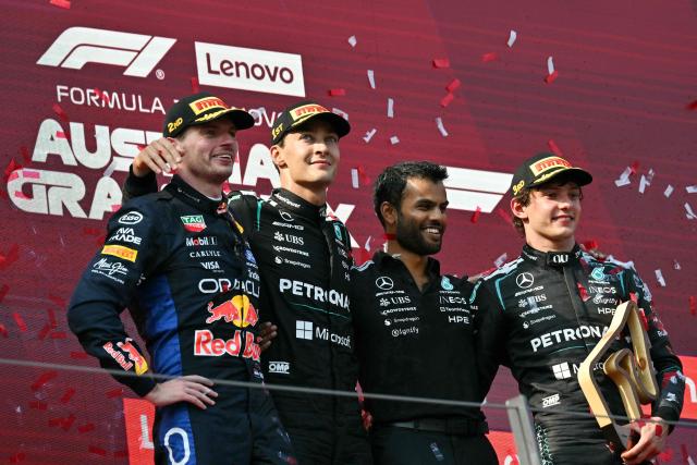 (L-R) Second placed Red Bull Racing's Dutch driver Max Verstappen, winner Mercedes' British driver George Russell, a Mercedes teammember and third placed Mercedes' Italian driver Kimi Antonelli celebrate on the podium after the Formula One Austrian Grand Prix at the Red Bull Ring race track in Spielberg, Austria on June 28, 2026. (Photo by Andrej ISAKOVIC / AFP)