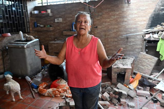 Maria Esther Bernal speaks during an interview with AFP inside her house partially damaged by the earthquakes in Catia La Mar, La Guaira state, Venezuela, on June 28, 2026. Thousands of rescuers, relatives and volunteers dig day and night through mounds of concrete to find survivors of the earthquakes that struck Venezuela more than three days ago, leaving nearly 1,500 dead and tens of thousands missing. (Photo by Juan BARRETO / AFP)
