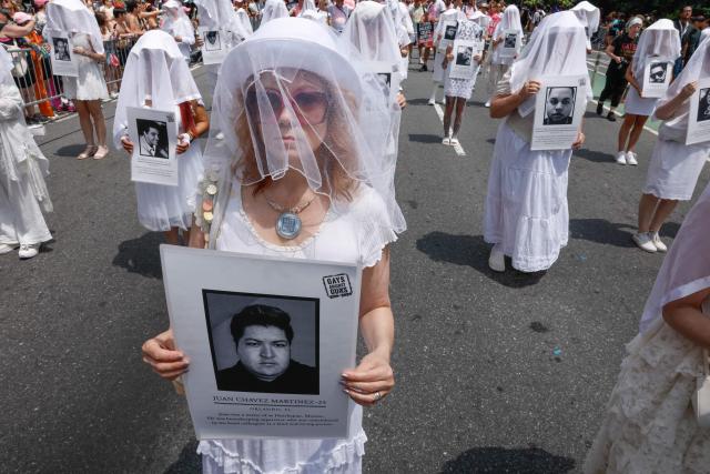 Activists from “Gays Against Guns” hold photographs of victims as they march for LGBTQ rights during the annual New York City Pride March in New York on June 28, 2026. (Photo by kena betancur / AFP)