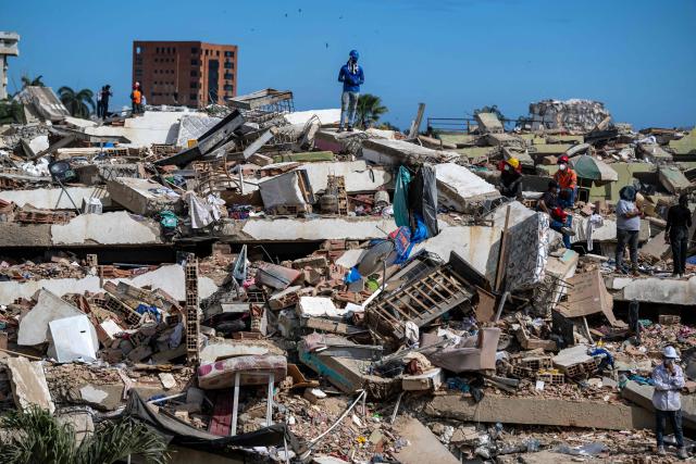 Volunteers and residents search for survivors on the rubble of collapsed buildings in Caraballeda, La Guaira state, Venezuela, on June 28, 2026, following earthquakes. Thousands of rescuers, relatives and volunteers dig day and night through mounds of concrete to find survivors of the earthquakes that struck Venezuela more than three days ago, leaving nearly 1,500 dead and tens of thousands missing. (Photo by Miguel MEDINA / POOL / AFP)