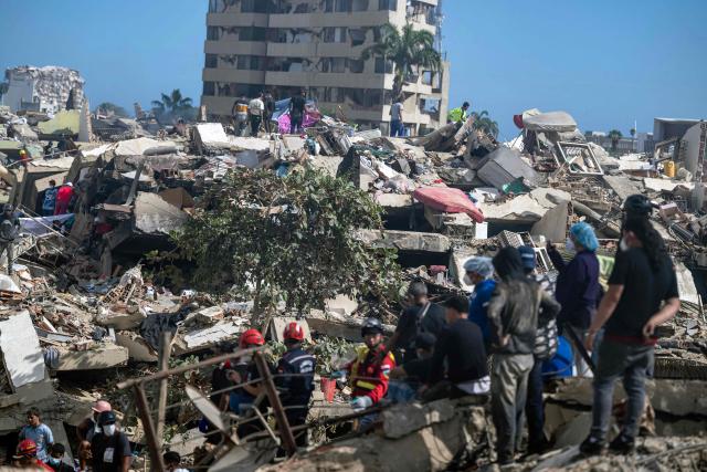 Rescuers, volunteers and residents search for survivors on the rubble of collapsed buildings in Caraballeda, La Guaira state, Venezuela, on June 28, 2026, following earthquakes. Thousands of rescuers, relatives and volunteers dig day and night through mounds of concrete to find survivors of the earthquakes that struck Venezuela more than three days ago, leaving nearly 1,500 dead and tens of thousands missing. (Photo by Miguel MEDINA / POOL / AFP)
