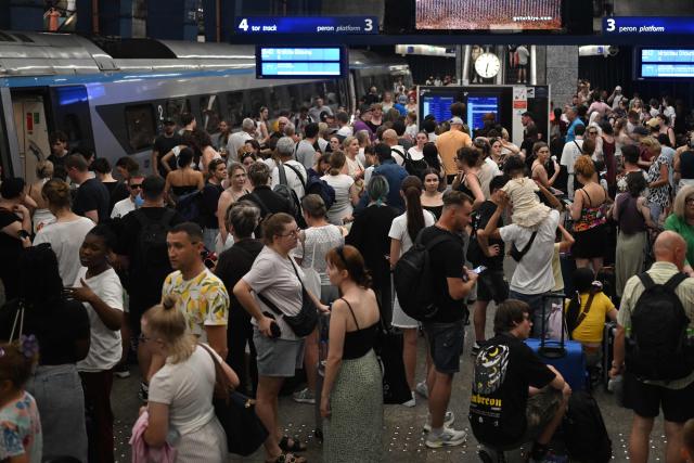 Passengers stand on the platform waiting for trains delayed due to the heatwave at Warsaw Central railway station in Warsaw on June 28, 2026. Poland surpassed its all-time heat record with temperatures reaching 40.5C, a spokeswoman for the Institute of Meteorology and Water Management (IMGW) told to AFP on June 28, 2026. (Photo by Sergei GAPON / AFP)
