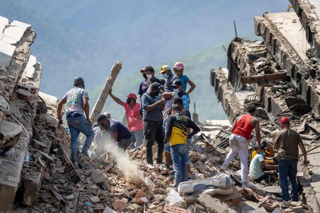 Volunteers and residents search for survivors on the rubble of collapsed buildings in Caraballeda, La Guaira state, Venezuela, on June 28, 2026, following earthquakes. Thousands of rescuers, relatives and volunteers dig day and night through mounds of concrete to find survivors of the earthquakes that struck Venezuela more than three days ago, leaving nearly 1,500 dead and tens of thousands missing. (Photo by Miguel MEDINA / POOL / AFP)