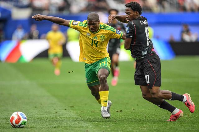 South Africa's defender #14 Mbekezeli Mbokazi and Canada's forward #10 Jonathan David fight for the ball during the 2026 World Cup round of 32 football match between South Africa and Canada at the Los Angeles Stadium in Inglewood on June 28, 2026.  (Photo by Patrick T. Fallon / AFP)