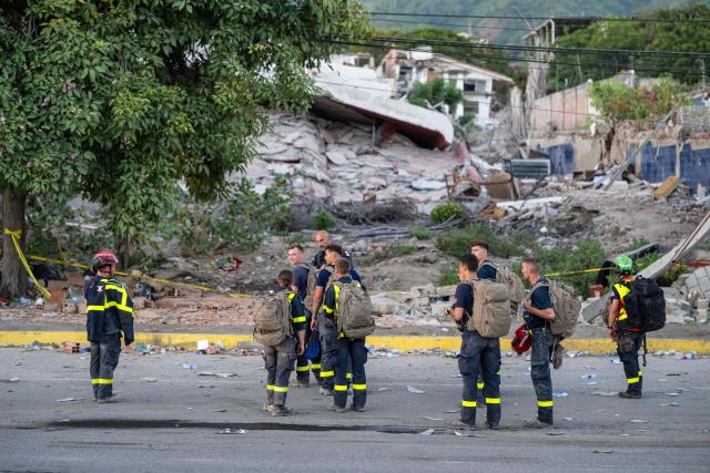 Members of the French Civil Security Training and Intervention Regiment (UIISC 7) walk along a street in La Guaira state, Venezuela, on June 28, 2026, following earthquakes. Thousands of rescuers, relatives and volunteers dig day and night through mounds of concrete to find survivors of the earthquakes that struck Venezuela more than three days ago, leaving nearly 1,500 dead and tens of thousands missing. (Photo by Miguel MEDINA / POOL / AFP)