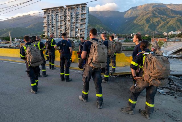 Members of the French Civil Security Training and Intervention Regiment (UIISC 7) walk along a street in La Guaira state, Venezuela, on June 28, 2026, following earthquakes. Thousands of rescuers, relatives and volunteers dig day and night through mounds of concrete to find survivors of the earthquakes that struck Venezuela more than three days ago, leaving nearly 1,500 dead and tens of thousands missing. (Photo by Miguel MEDINA / POOL / AFP)
