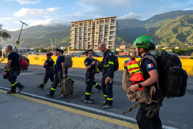 Members of the French Civil Security Training and Intervention Regiment (UIISC 7) walk in an area affected by building collapses in La Guaira state, Venezuela, on June 28, 2026, following earthquakes. Thousands of rescuers, relatives and volunteers dig day and night through mounds of concrete to find survivors of the earthquakes that struck Venezuela more than three days ago, leaving nearly 1,500 dead and tens of thousands missing. (Photo by Miguel MEDINA / POOL / AFP)