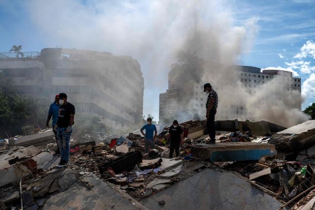Rescuers and volunteers search for survivors in La Guaira, La Guaira state, Venezuela, on June 28, 2026, following twin earthquakes. Thousands of rescuers, relatives and volunteers dig day and night through mounds of concrete to find survivors of the earthquakes that struck Venezuela more than three days ago, leaving nearly 1,500 dead and tens of thousands missing. (Photo by Miguel MEDINA / POOL / AFP)