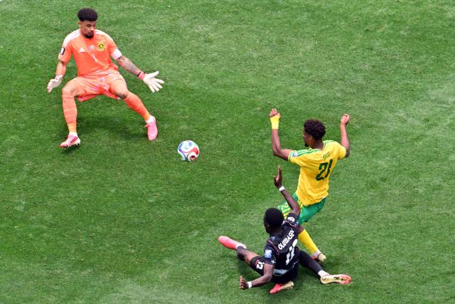Canada's forward #12 Tani Oluwaseyi kicks the ball and misses a chance past South Africa's goalkeeper #01 Ronwen Williams and defender #21 Ime Okon during the 2026 World Cup round of 32 football match between South Africa and Canada at the Los Angeles Stadium in Inglewood on June 28, 2026.  (Photo by Frederic J. Brown / AFP)