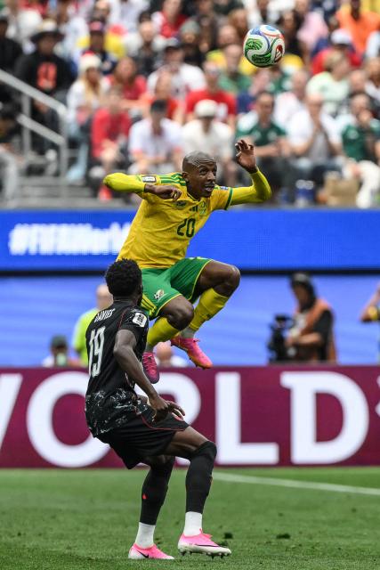 South Africa's defender #20 Khuliso Mudau heads the ball past Canada's defender #19 Alphonso Davies during the 2026 World Cup round of 32 football match between South Africa and Canada at the Los Angeles Stadium in Inglewood on June 28, 2026.  (Photo by Patrick T. Fallon / AFP)