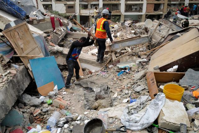 A rescuer breaks up the rubble with a pickaxe while trying to retrieve a body in Caraballeda, La Guaira State, Venezuela on June 28, 2026, following twin earthquakes. Thousands of rescuers, relatives and volunteers dig day and night through mounds of concrete to find survivors of the earthquakes that struck Venezuela more than three days ago, leaving nearly 1,500 dead and tens of thousands missing. (Photo by Mauricio VALENZUELA / AFP)