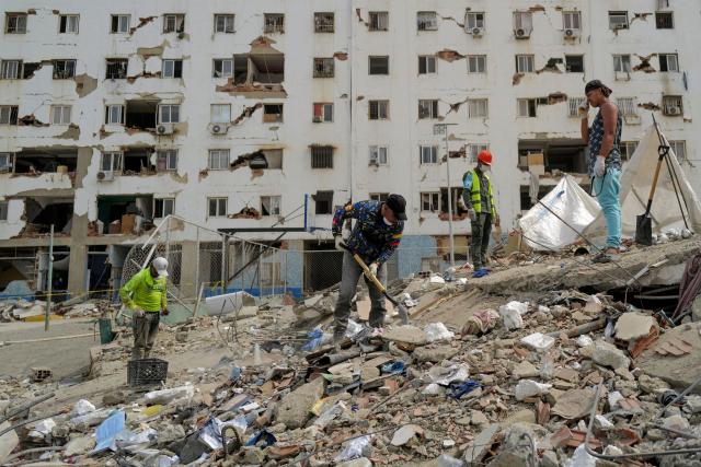 A rescuer digs amid rubble while searching for victims in Caraballeda, La Guaira State, Venezuela on June 28, 2026, following twin earthquakes. Thousands of rescuers, relatives and volunteers dig day and night through mounds of concrete to find survivors of the earthquakes that struck Venezuela more than three days ago, leaving nearly 1,500 dead and tens of thousands missing. (Photo by Mauricio VALENZUELA / AFP)