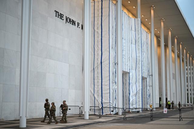 National Gaurd troops patrol outside the Kennedy Center, the facade of which remains covered with a tarp, in Washington, DC, on June 28, 2026. A US federal judge asked on June 24 for an explanation for why a tarpaulin continues to cover the facade of the Kennedy Center where President Donald Trump's name was recently removed. District Judge Christopher Cooper gave the board of trustees of the performing arts venue until the end of July to explain "the purpose for and status of the tarp and scaffolding that Defendants have erected on the front portico of the Center." (Photo by Alex WROBLEWSKI / AFP)