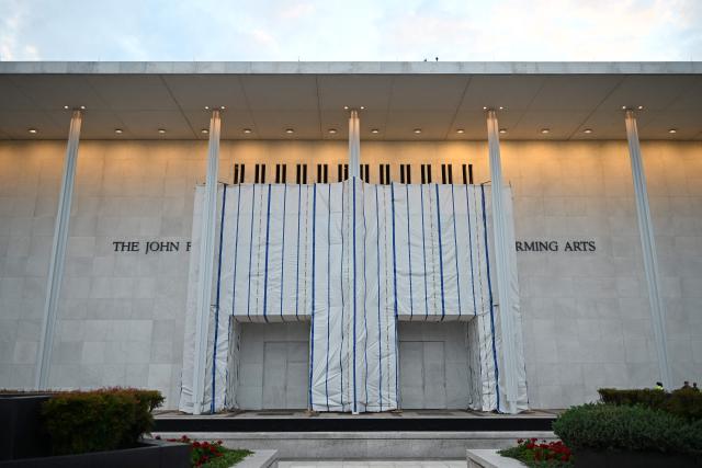 The Kennedy Center, the facade of which remains covered with a tarp, is seen in Washington, DC, on June 28, 2026. A US federal judge asked on June 24 for an explanation for why a tarpaulin continues to cover the facade of the Kennedy Center where President Donald Trump's name was recently removed. District Judge Christopher Cooper gave the board of trustees of the performing arts venue until the end of July to explain "the purpose for and status of the tarp and scaffolding that Defendants have erected on the front portico of the Center." (Photo by Alex WROBLEWSKI / AFP)