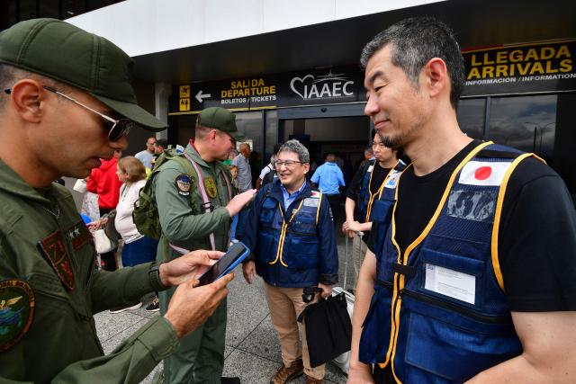 Members of Venezuela's Bolivarian National Guard greet rescuers of the Japan International Cooperation Agency on arrival at the Arturo Michelena international airport in Valencia, Carabobo state, Venezuela, to help in search operations following twin earthquakes, on June 28, 2026. Thousands of rescuers, relatives and volunteers dig day and night through mounds of concrete to find survivors of the earthquakes that struck Venezuela more than three days ago, leaving nearly 1,500 dead and tens of thousands missing. (Photo by Jacinto OLIVEROS / AFP)
