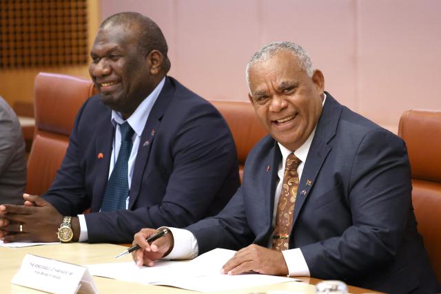 Vanuatu's Prime Minister Jotham Napat (R) and Foreign Minister Marc Ati smile during a meeting with Australian Prime Minister Anthony Albanese and cabinet members at Parliament House in Canberra on June 29, 2026. (Photo by David GRAY / AFP)