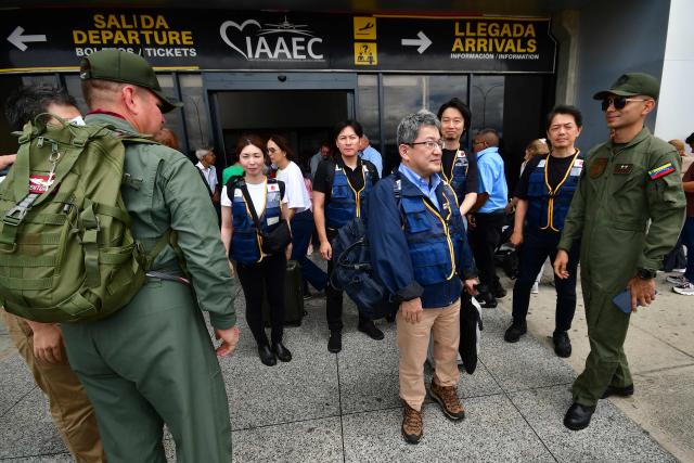 Members of Venezuela's Bolivarian National Guard greet rescuers of the Japan International Cooperation Agency on arrival at the Arturo Michelena international airport in Valencia, Carabobo state, Venezuela, to help in search operations following twin earthquakes, on June 28, 2026. Thousands of rescuers, relatives and volunteers dig day and night through mounds of concrete to find survivors of the earthquakes that struck Venezuela more than three days ago, leaving nearly 1,500 dead and tens of thousands missing. (Photo by Jacinto OLIVEROS / AFP)