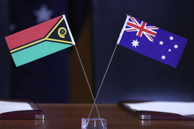 The national flags of Australia (R) and Vanuatu are seen on a table ahead of a signing ceremony during Vanuatu Prime Minister Jotham Napat’s visit at Parliament House in Canberra on June 29, 2026. (Photo by David GRAY / AFP)