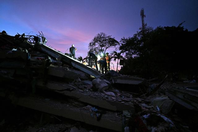Volunteers and Ecuadorean firefighters of the Urban Search and Rescue (USAR) search for bodies at the site of a collapsed building in Caraballeda, La Guaira State, Venezuela on June 28, 2026, following twin earthquakes. Thousands of rescuers, relatives and volunteers dig day and night through mounds of concrete to find survivors of the earthquakes that struck Venezuela more than three days ago, leaving nearly 1,500 dead and tens of thousands missing. (Photo by Juan BARRETO / AFP)