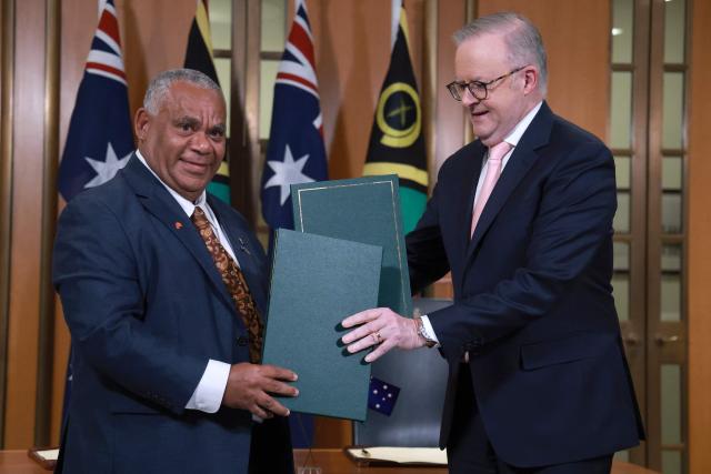Australian Prime Minister Anthony Albanese (R) and Vanuatu's Prime Minister Jotham Napat exchange signed copies of The Nakamal Agreement during a signing ceremony at Parliament House in Canberra on June 29, 2026. (Photo by DAVID GRAY / AFP)