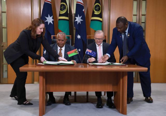 Australian Prime Minister Anthony Albanese (2nd R) and Vanuatu's Prime Minister Jotham Napat (2nd L) sign The Nakamal Agreement during a signing ceremony at Parliament House in Canberra on June 29, 2026. (Photo by DAVID GRAY / AFP)