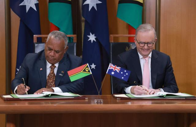 Australian Prime Minister Anthony Albanese (R) and Vanuatu's Prime Minister Jotham Napat sign The Nakamal Agreement during a signing ceremony at Parliament House in Canberra on June 29, 2026. (Photo by DAVID GRAY / AFP)