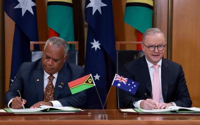 Australian Prime Minister Anthony Albanese (R) and Vanuatu's Prime Minister Jotham Napat sign The Nakamal Agreement during a signing ceremony at Parliament House in Canberra on June 29, 2026. (Photo by DAVID GRAY / AFP)