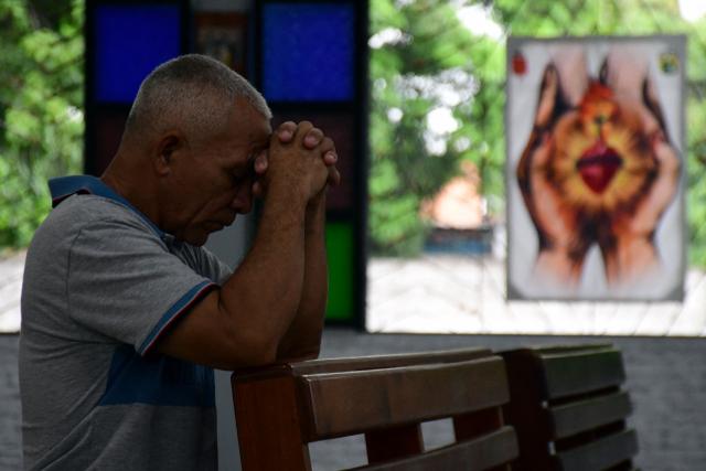 A man prays during a mass within the National Day of Prayer for the quake victims in Valencia, Carabobo state, Venezuela, following twin earthquakes, on June 28, 2026. Volunteers and emergency brigades with rescue dogs continue lifting mountains of rubble on in search of survivors of the twin earthquake that struck Venezuela four days ago, which completely brought down nearly 200 buildings and left at least 1,450 dead and tens of thousands missing. (Photo by Jacinto OLIVEROS / AFP)